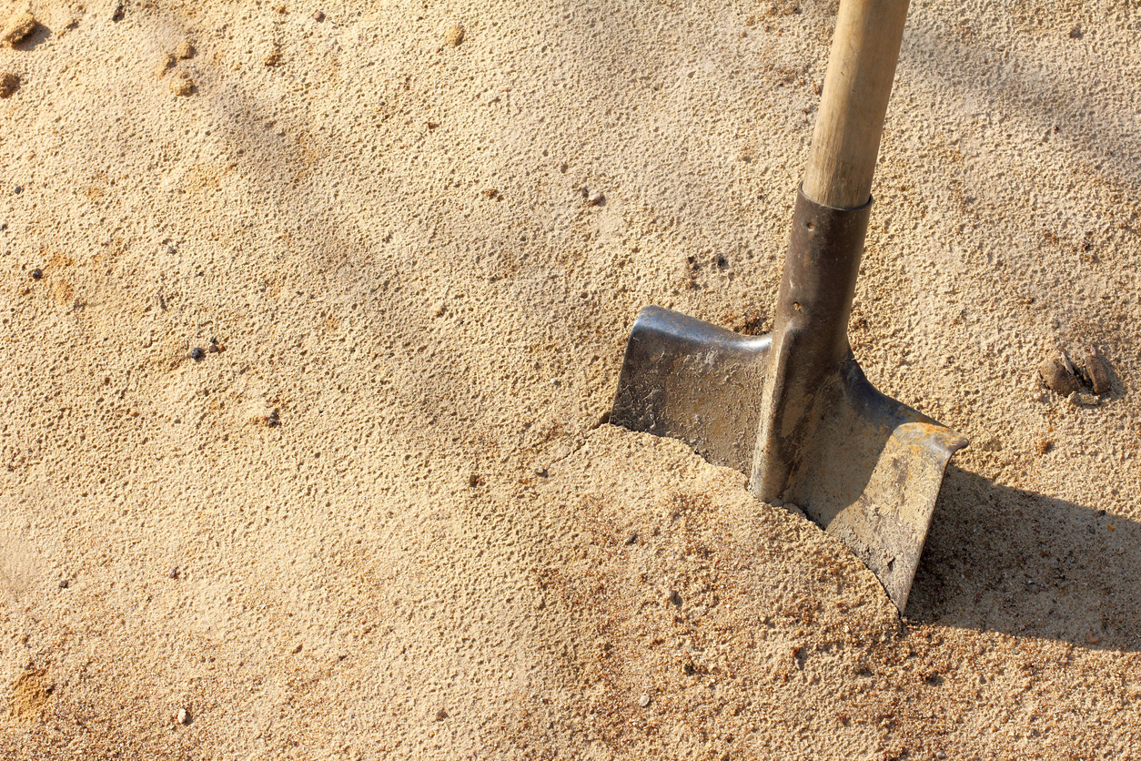 shovel digging into a pile of sand.